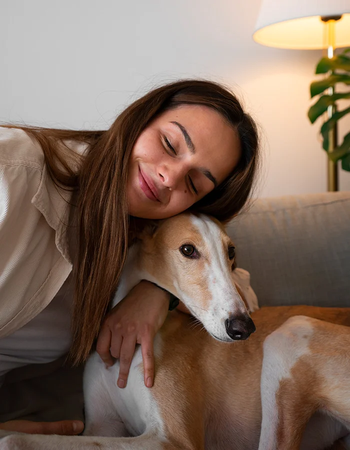 greyhound-cuddles A woman and her greyhound hug on the couch