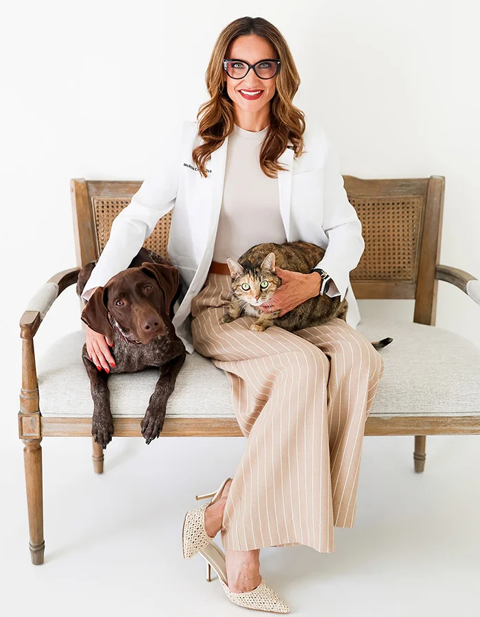 Dr. Melissa Cefalu sitting with a cat and dog